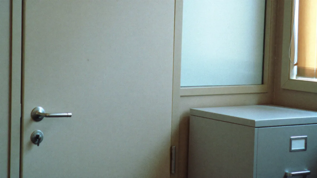 A private office door and a closed filing cabinet, standing for secure student records