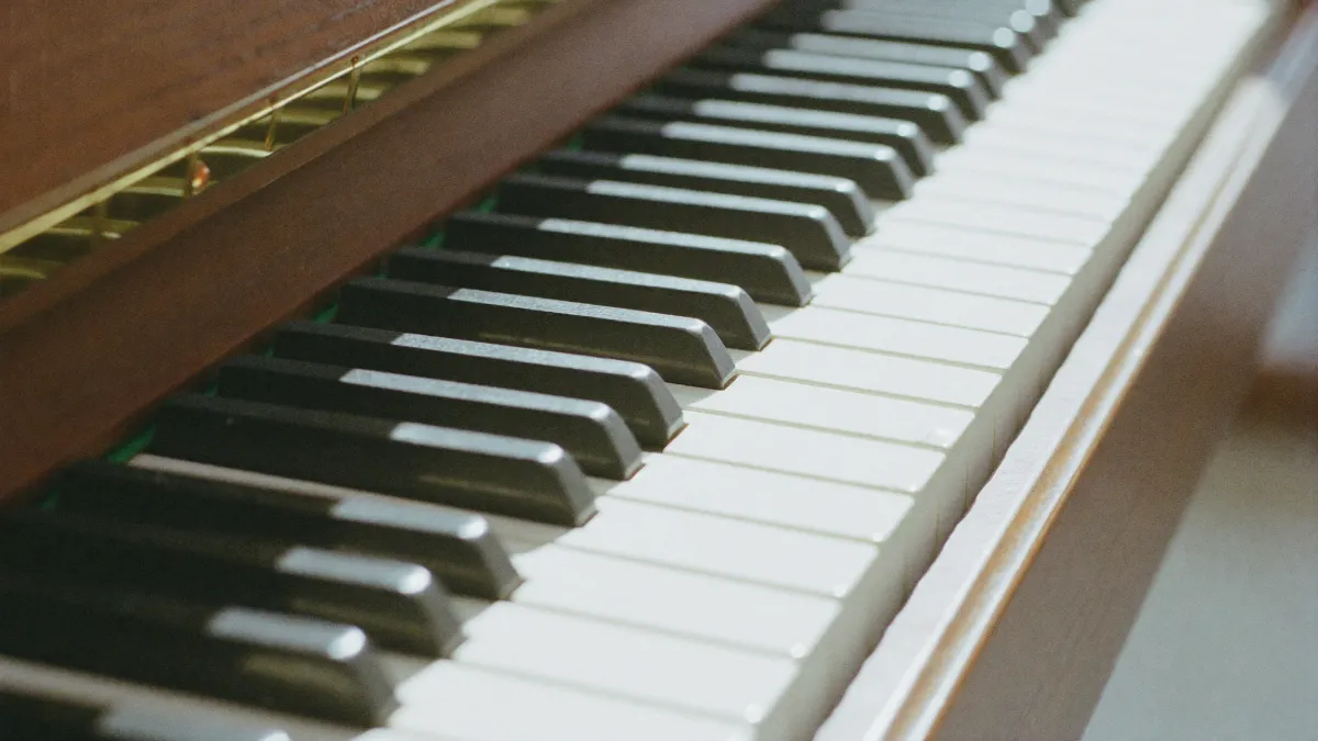 Close-up of upright piano keys in warm daylight