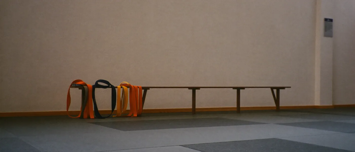 A martial arts dojo with tatami mats and folded practice belts