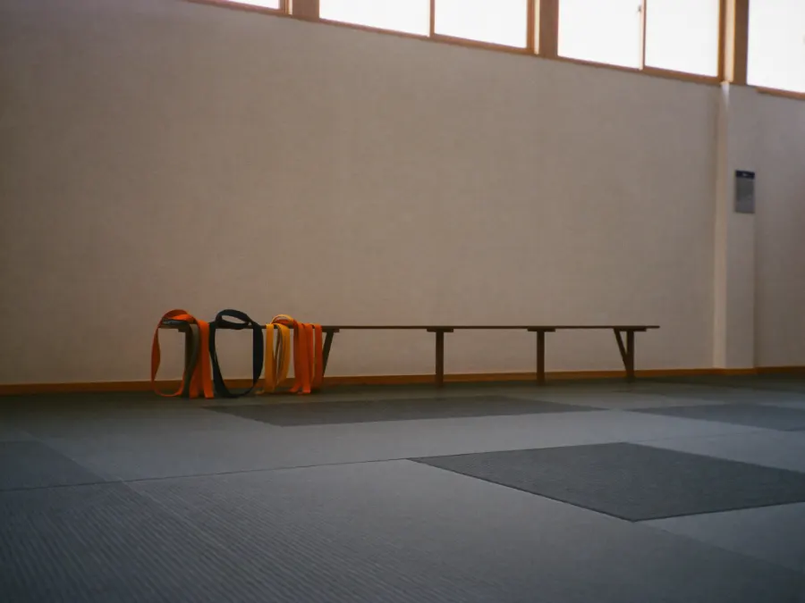 A martial arts dojo with tatami mats and folded practice belts