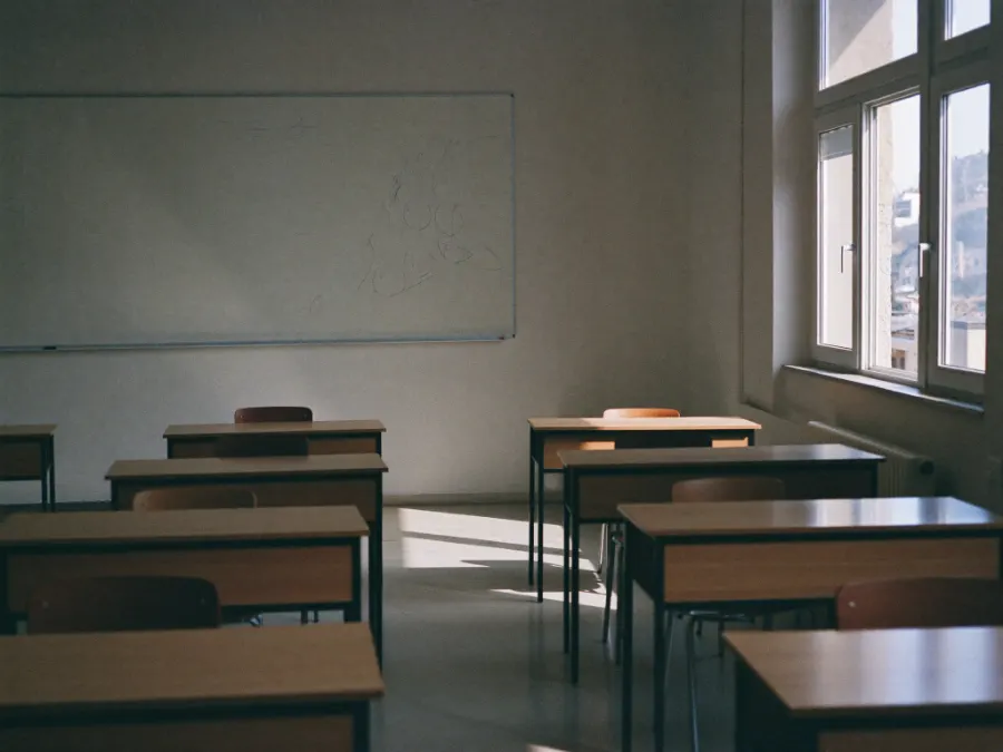 An empty tutoring centre classroom with desks and afternoon light